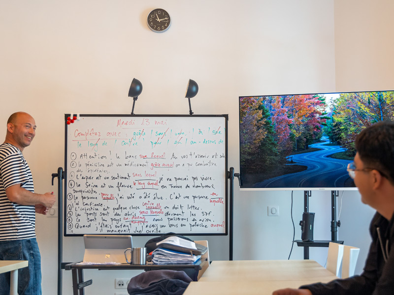 Lehrer erklärt Grammatik am Whiteboard in der Sprachschule Les Ateliers FL Biarritz – Unterricht einer Französisch-Sprachreise.