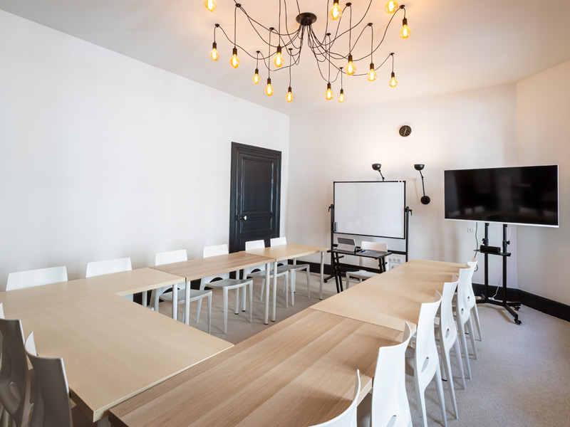 Heller Klassenraum mit U-Tisch-Bestuhlung für Französisch-Sprachkurse an der Sprachschule Les Ateliers FL Biarritz.