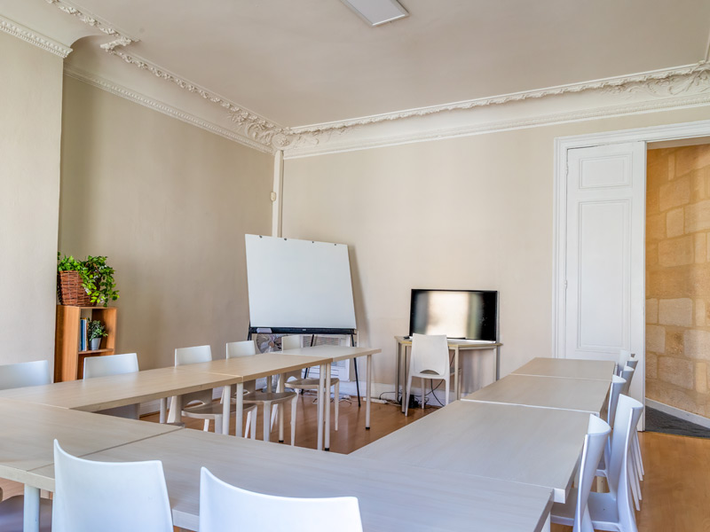 Freundlicher Klassenraum mit U-Form-Tischen für interaktiven Französischunterricht auf Sprachreise.