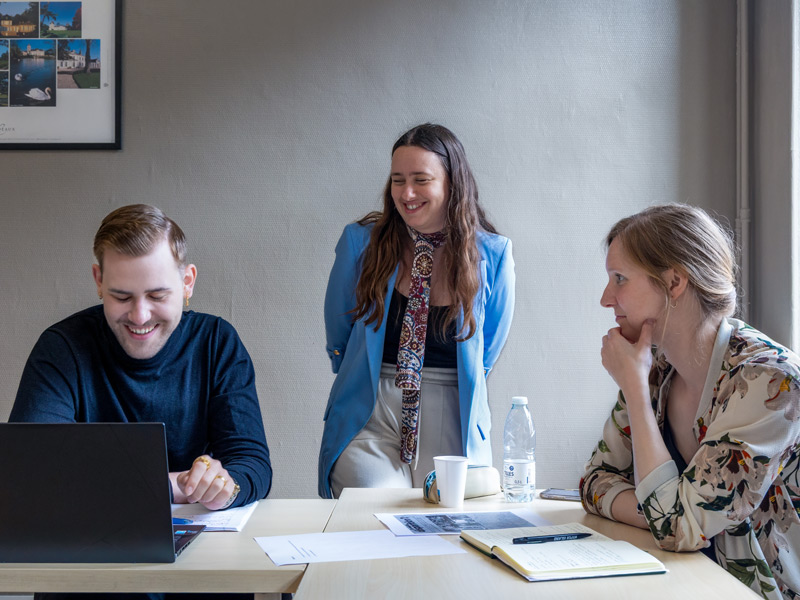 Kleingruppe auf Sprachreise arbeitet im Französischunterricht gemeinsam am Laptop und an Aufgaben.