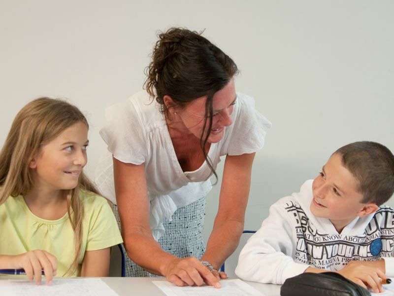 Sprachlehrerin unterstützt Kinder beim Lernen während des Haus des Lehrers Programms in Frankreich