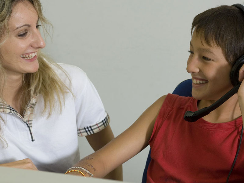 Lehrerin und Schüler lachen gemeinsam während des Einzelunterrichts im Haus des Lehrers in Frankreich