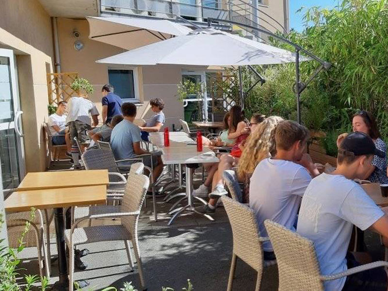 Schüler der Inlingua Sprachschule La Rochelle entspannen in der Sonne auf der Schulterrasse