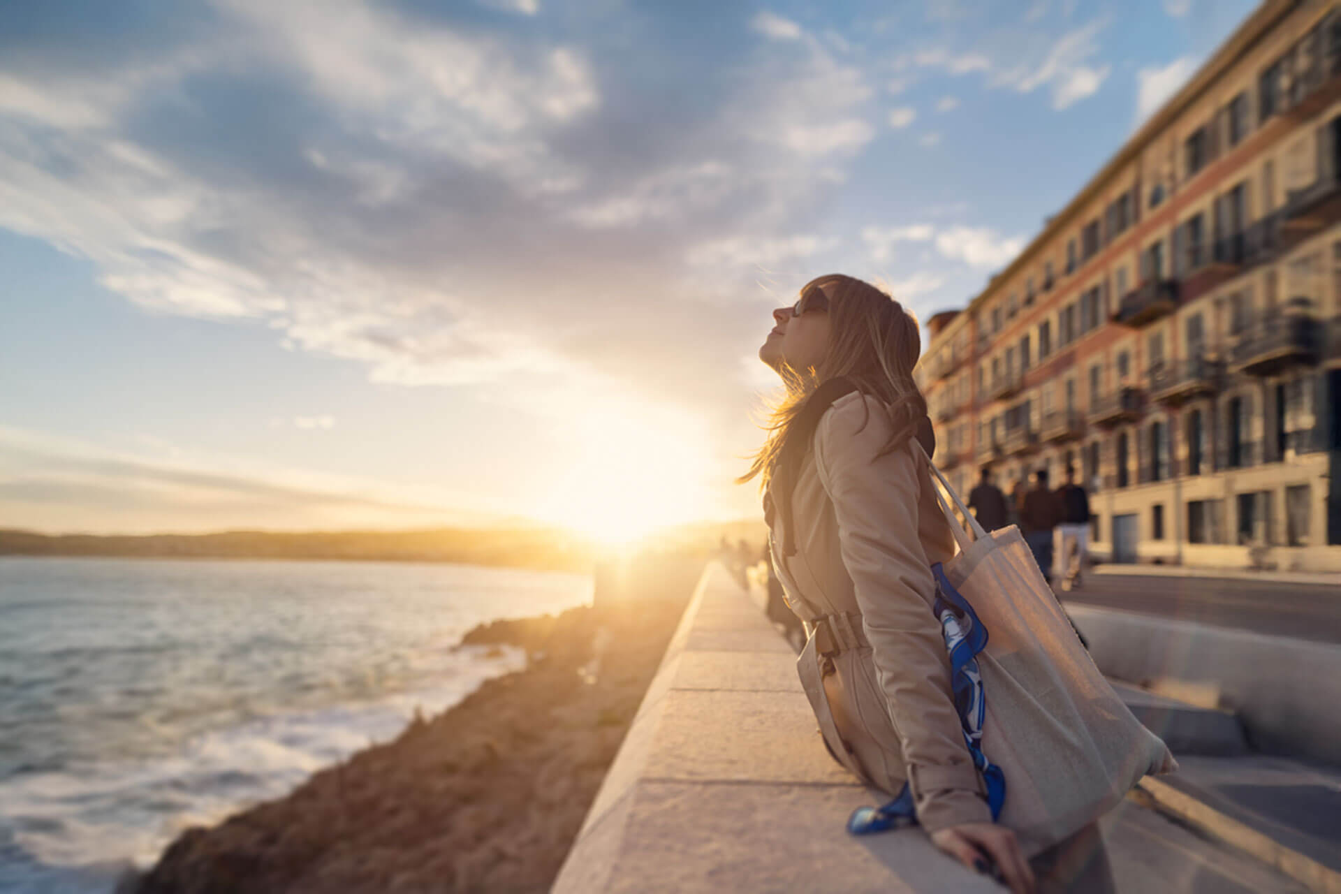Frau genießt den Sonnenuntergang an der Uferpromenade von La Rochelle in Frankreich