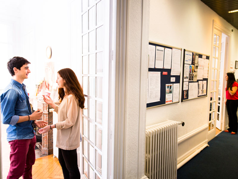 Sprachschüler der Alpadia Sprachschule Lyon im Schulflur im Gespräch