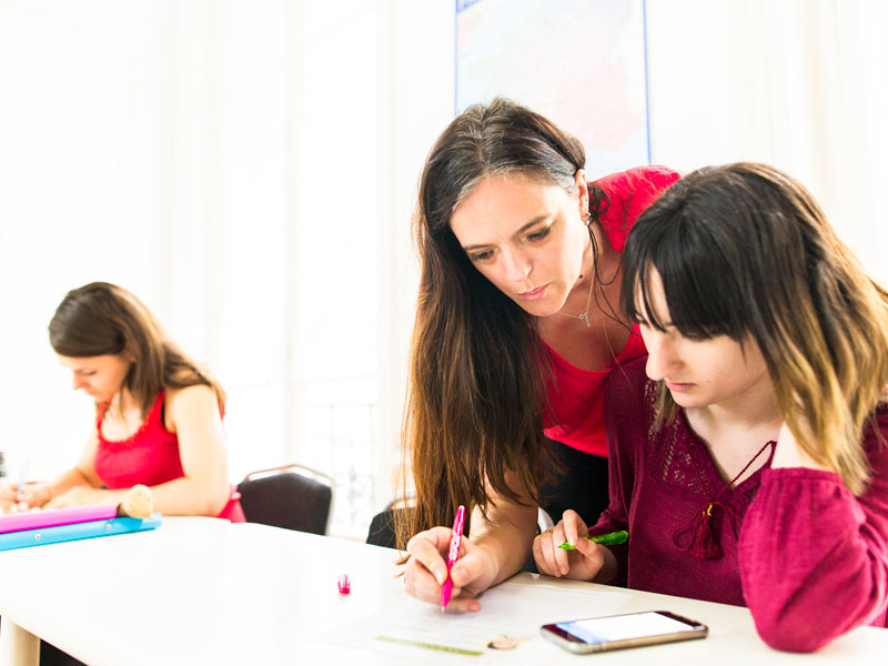 Lehrerin unterstützt Sprachschülerin beim Französischlernen an der Alpadia Sprachschule Lyon
