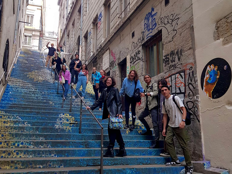 Sprachschüler der Les Ateliers FL Sprachschule Lyon auf einer farbenfrohen Treppe bei einem Stadtausflug