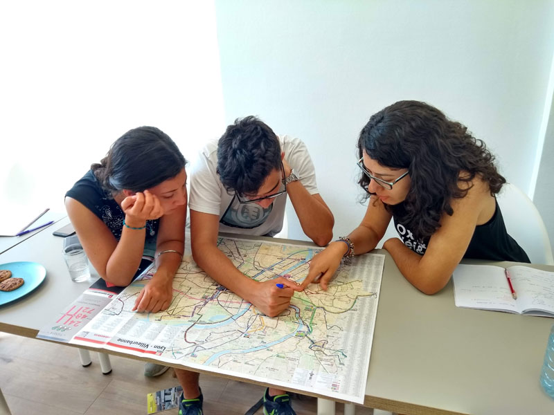 Sprachschüler der Les Ateliers FL Sprachschule Lyon bei Gruppenarbeit mit Stadtkarte
