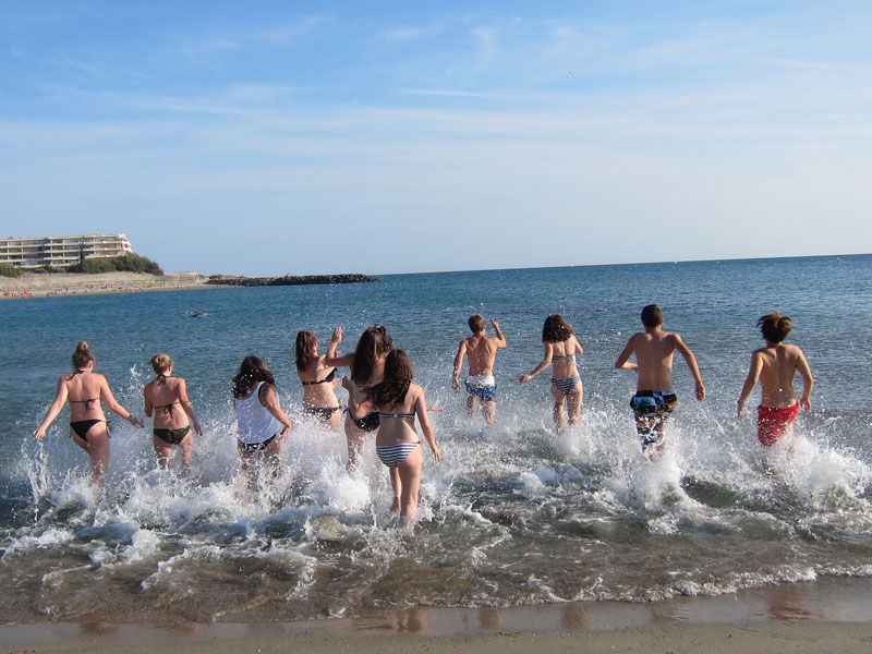 Kinder und Schüler beim Baden am Strand während des Sommercamps in Montpellier