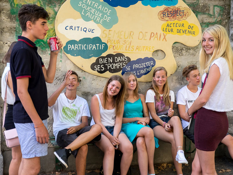 Schülergruppe im Sommercamp Montpellier mit Wandbild zu Gemeinschaft und Respekt
