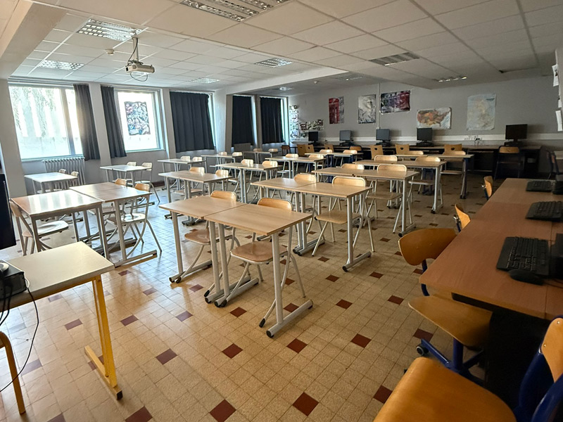 Helles Klassenzimmer des Eucalyptus Campus in Nizza mit Tischen, Stühlen und Computerarbeitsplätzen