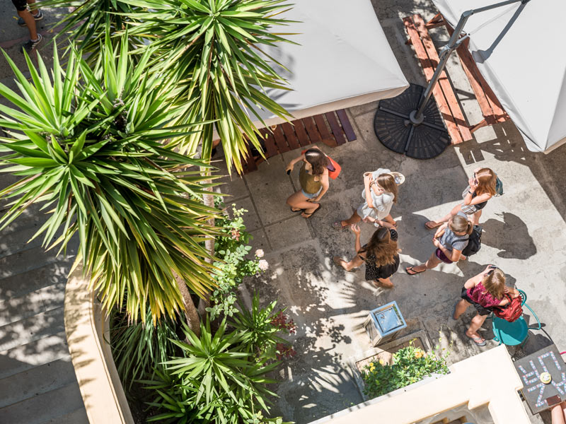 Schülerinnen im sonnigen Innenhof der Alpadia Sprachschule Nizza