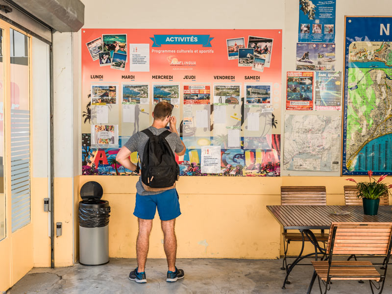 Sprachschüler informiert sich über Freizeitaktivitäten an der Alpadia Sprachschule Nizza