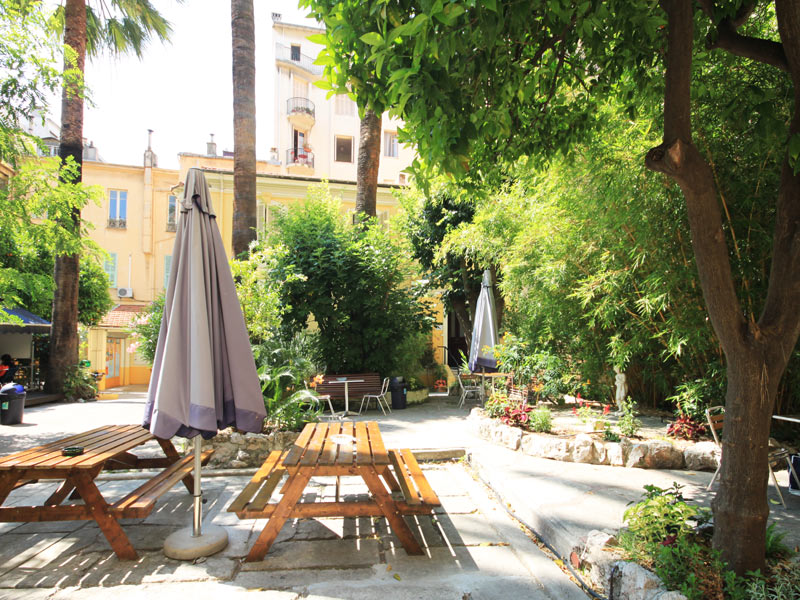 Grüner Garten mit Sitzgelegenheiten an der Alpadia Sprachschule Nizza