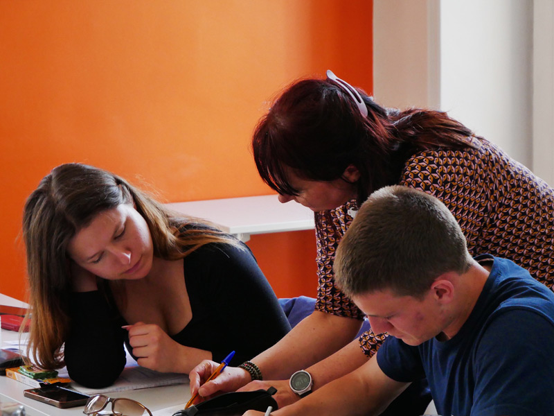 Lehrerin unterstützt Sprachschüler beim Französischlernen an der Alpha.b Sprachschule Nizza