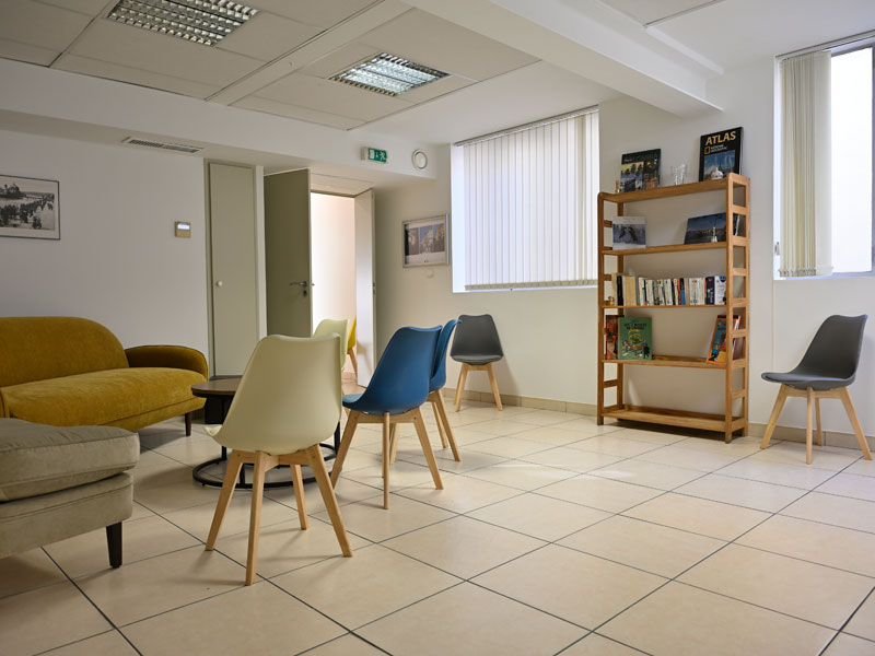 Espace détente dans l'école de langues de Nice avec sièges et bibliothèque.