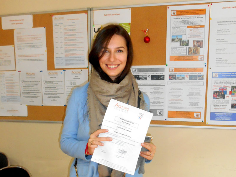 Sprachstudentin zeigt stolz ihr Teilnahmezertifikat an der Accord Sprachschule in Paris