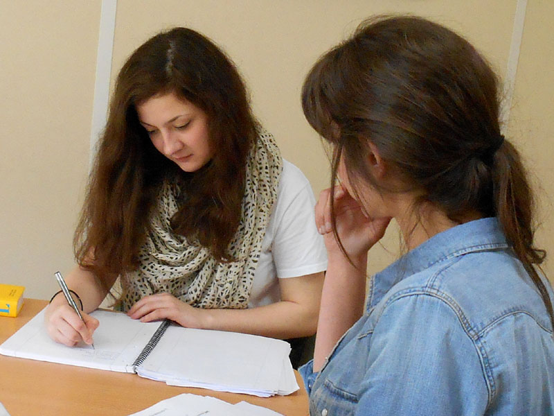 Zwei Sprachschülerinnen arbeiten gemeinsam an einer Französischübung in der Accord Sprachschule Paris