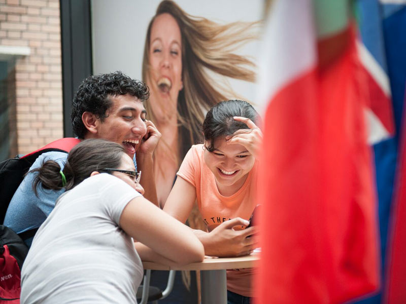 Internationale Sprachschüler lachen gemeinsam in der Cavilam Sprachschule in Vichy