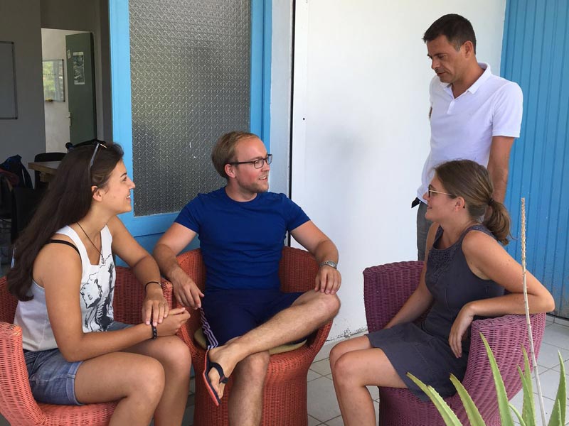 Kleine Gruppe sitzt entspannt auf der Terrasse und unterhält sich in freundlicher Atmosphäre
