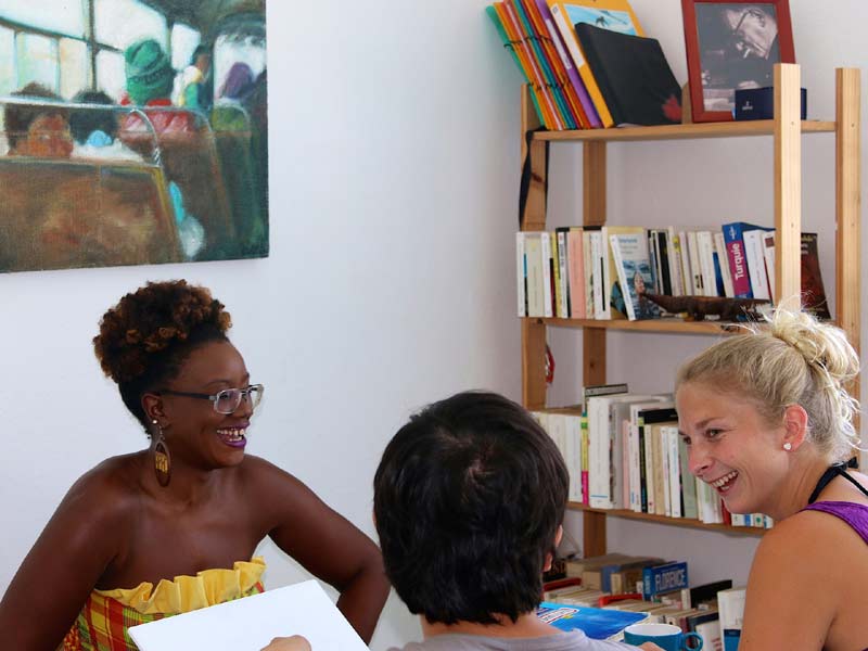 ehrkraft unterrichtet in kleiner Gruppe in gemütlicher Atmosphäre an der Sprachschule