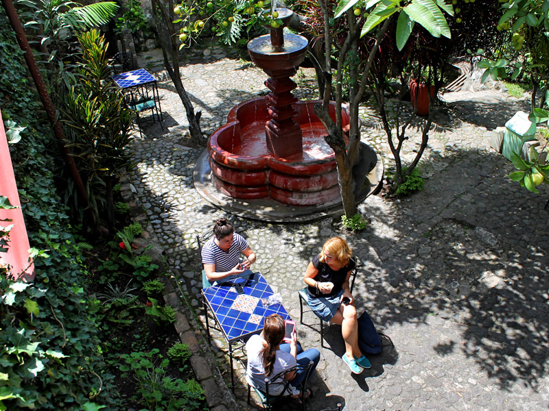 Schülerinnen beim Lernen und Entspannen im Innenhof mit Springbrunnen