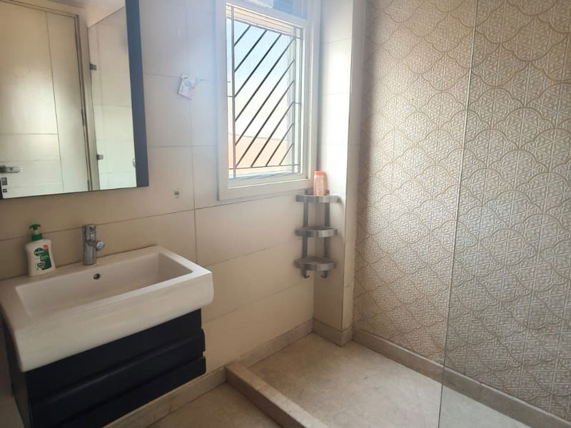 Modernes Badezimmer im Apartment in Neu-Delhi mit Dusche und Waschbereich.