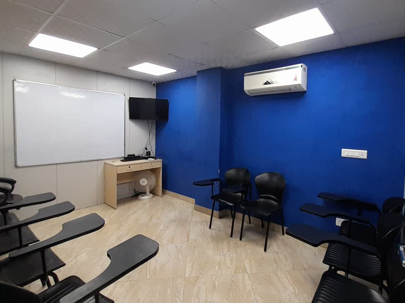 Moderner Klassenraum der ILSC Neu-Delhi mit blauer Wand, Whiteboard und TV-Bildschirm