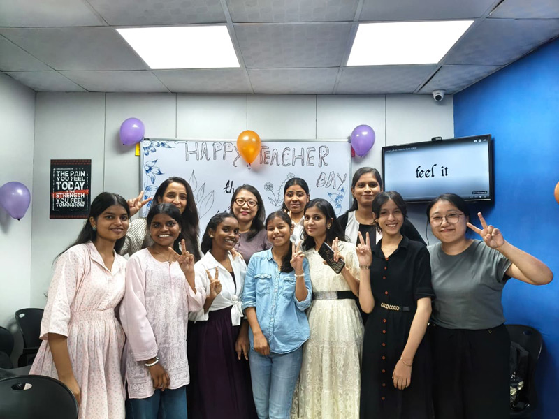 Gruppe von Teilnehmenden feiert gemeinsam in einem bunt geschmückten Klassenraum