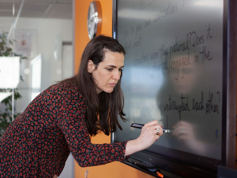 Englischlehrerin schreibt an interaktives Whiteboard an der EC Sprachschule Dublin