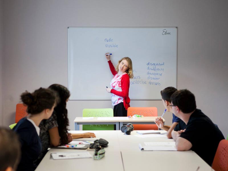 Lehrkraft erklärt Vokabeln an der Tafel während des Unterrichts