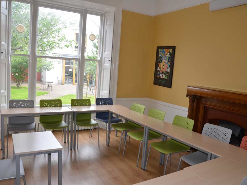 Heller Klassenraum der Emerald Sprachschule Dublin mit Blick auf den begrünten Innenhof