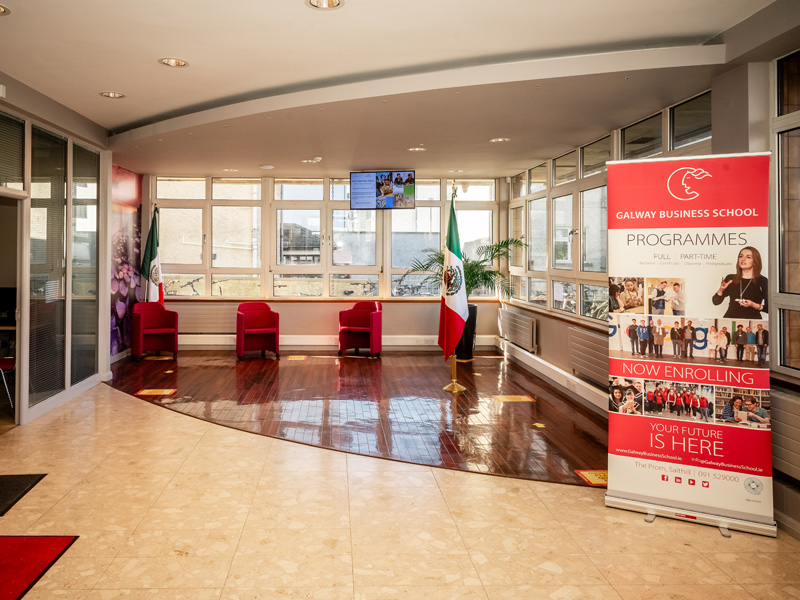 Heller Empfangsbereich der Galway Business School mit Informationsbanner und Sitzmöglichkeiten