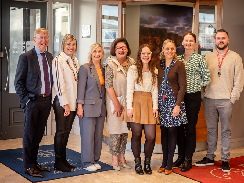 Team der Galway Business School steht im Eingangsbereich und lächelt in die Kamera