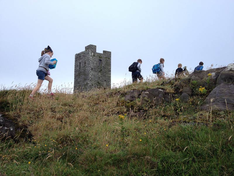 Kinder wandern zum historischen Turm bei Schull