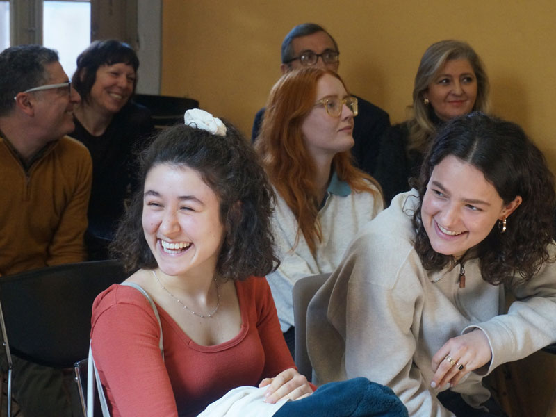 Lernende sitzen im Klassenraum und lachen während des Unterrichts an der Sprachschule