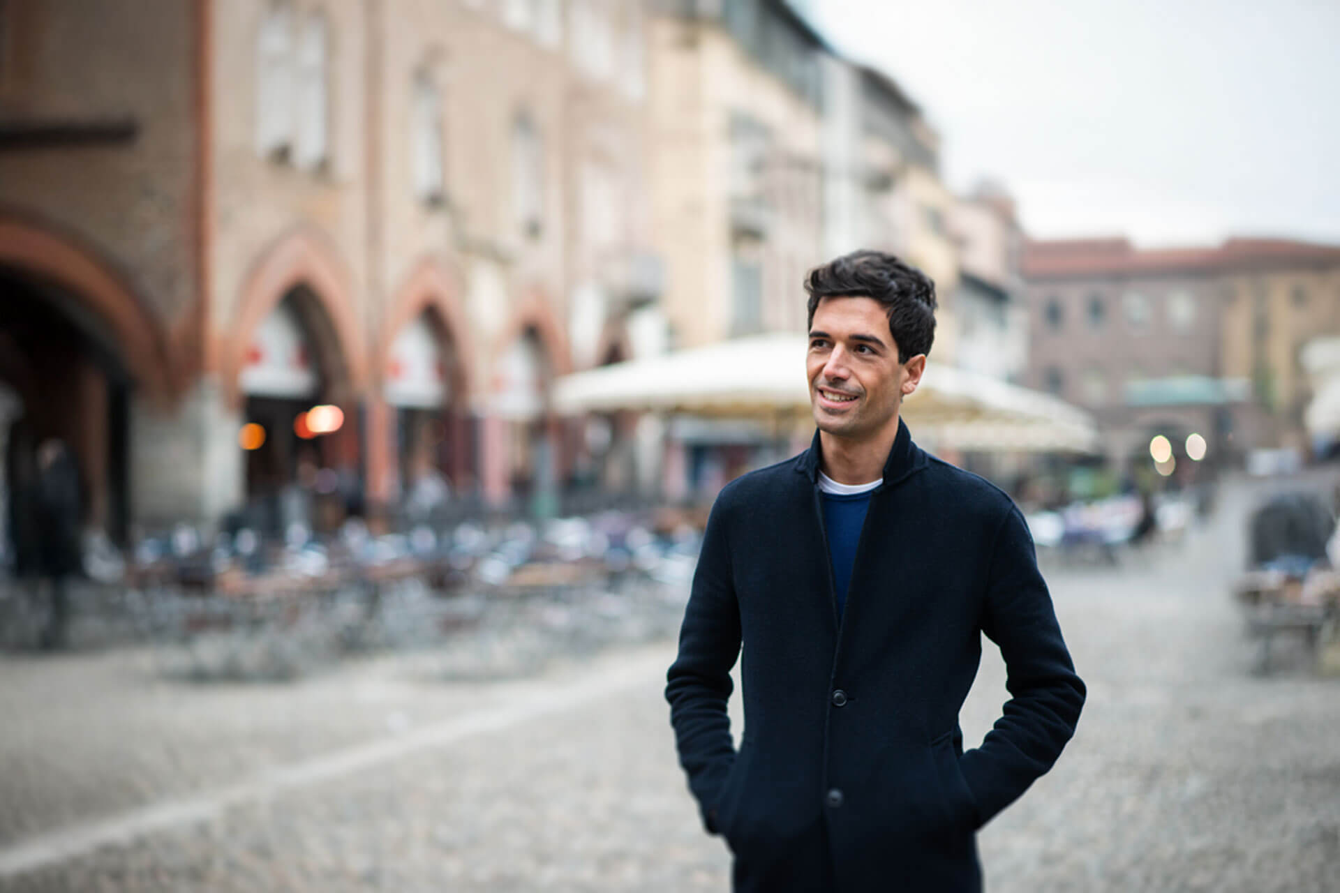 Person spaziert durch die Altstadt von Bologna mit historischen Gebäuden im Hintergrund