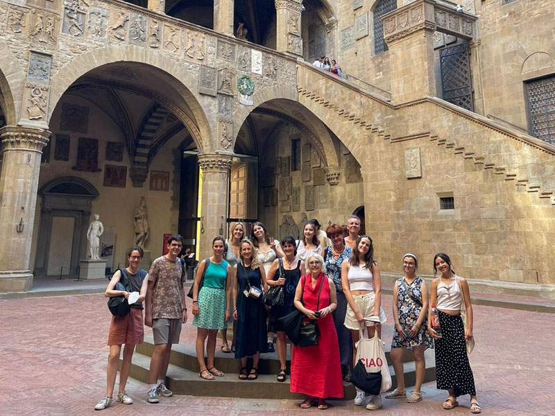 Gruppe von Sprachschülerinnen und -schülern bei einem Ausflug im Innenhof eines historischen Gebäudes in Florenz
