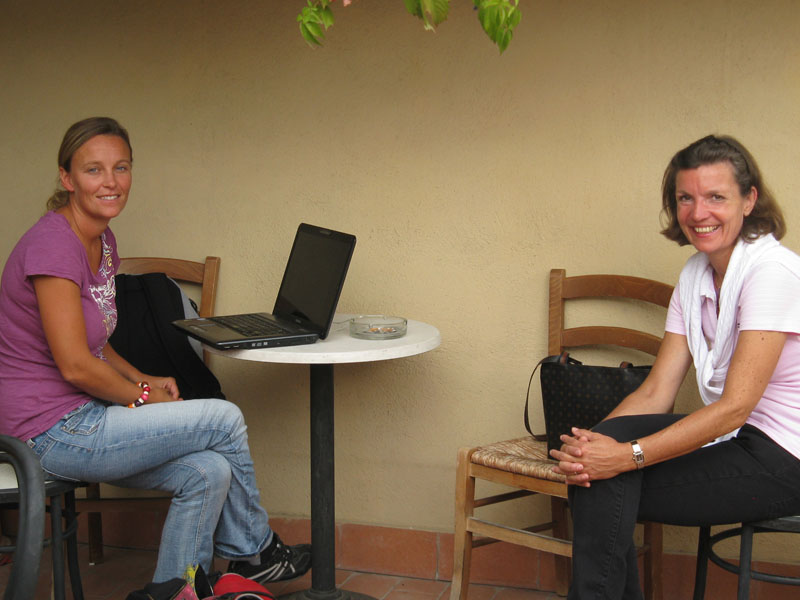 Zwei Frauen lernen gemeinsam auf einer Terrasse mit Laptop