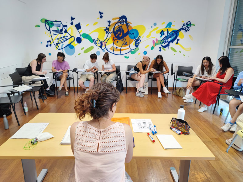 Lezione di gruppo di italiano a Milano studenti imparano insieme durante il soggiorno linguistico