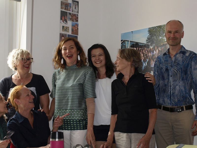 Mehrere Erwachsene lachen gemeinsam während einer Unterrichtspause in der Sprachschule