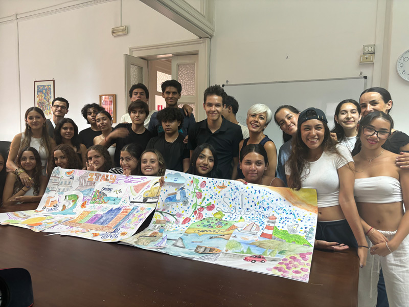 Gruppe von Jugendlichen zeigt ihre farbenfrohen Kunstwerke in einem Klassenraum