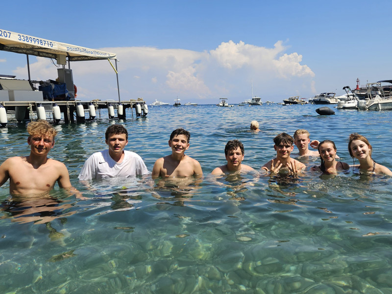 Gruppe Jugendlicher schwimmt und entspannt im klaren Meerwasser vor der Küste von Salerno
