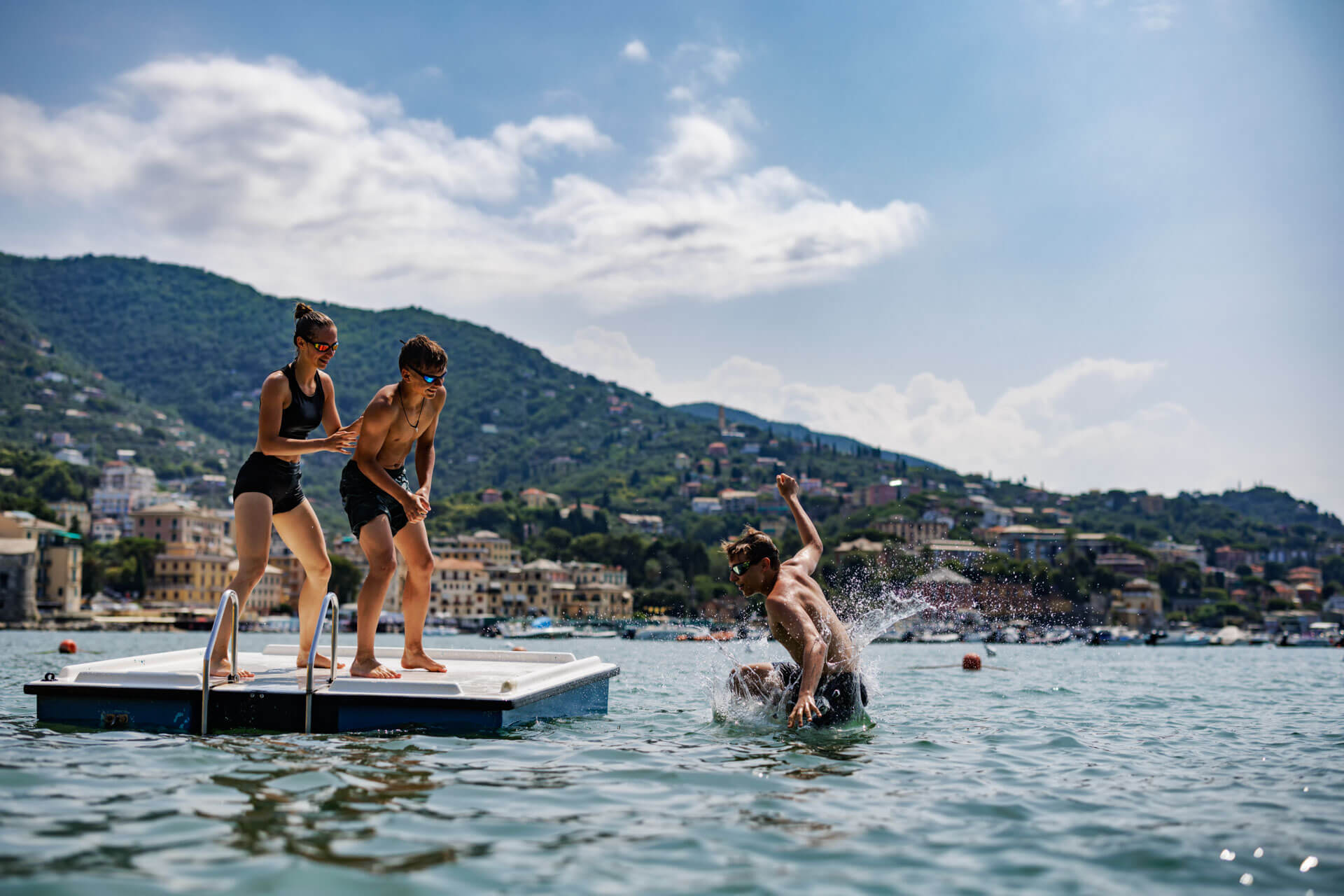 Jugendliche genießen den Sommer auf einem Schwimmponton vor der Küste von Salerno