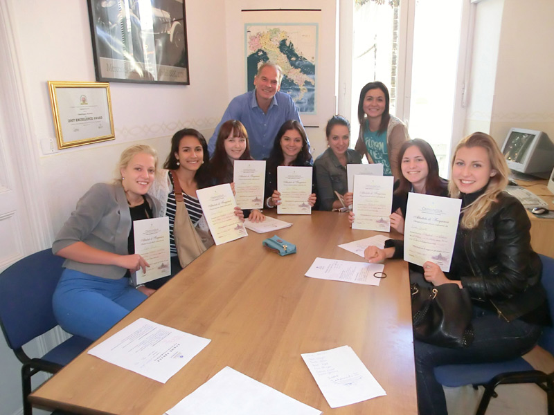 ruppe von Sprachschülern zeigt stolz ihre Teilnahmezertifikate nach Kursabschluss