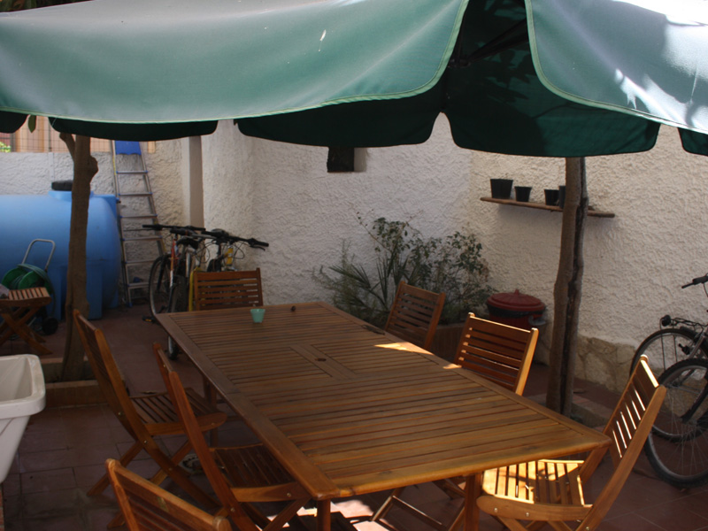 Gemütlicher Innenhof mit Holztisch und Sonnenschirm, ideal zum Lernen oder Entspannen