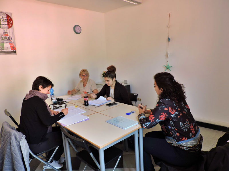 Kleine Gruppe Erwachsener beim Italienischunterricht in einem hellen Klassenraum der Sprachschule