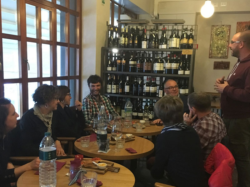 Sprachschüler sitzen gemütlich in einer Weinstube und nehmen an einer Weinverkostung teil