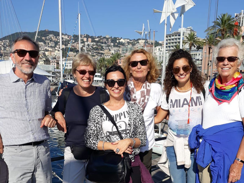 Gruppe von Sprachschülern bei einem Ausflug zum Hafen von Genua mit Blick auf die Stadt