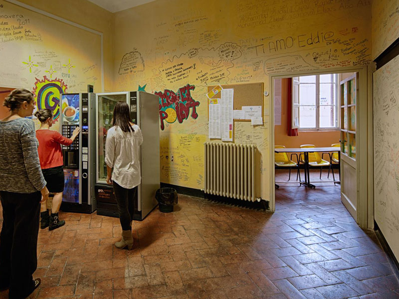 Sprachschüler nutzen den Pausenbereich mit Getränkeautomaten in der Dante Alighieri Sprachschule Siena